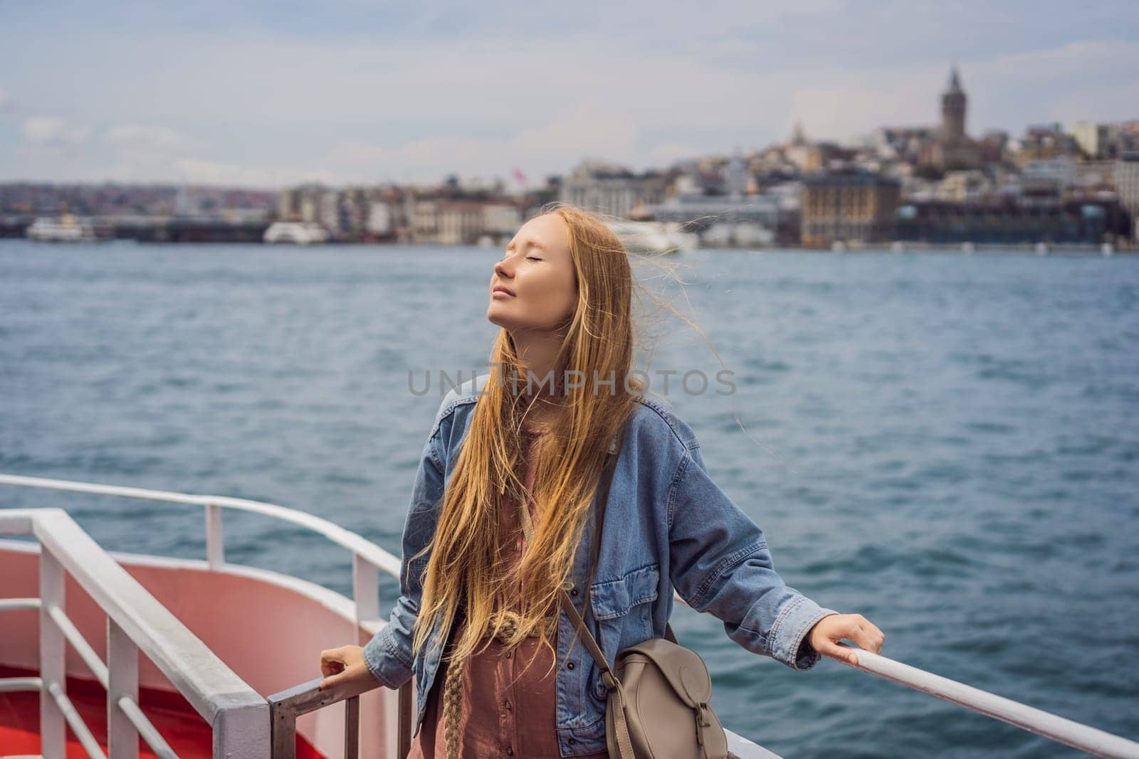 Happy woman enjoying the sea from ferry boat crossing Bosphorus in Istanbul. Summer trip to Istanbul.