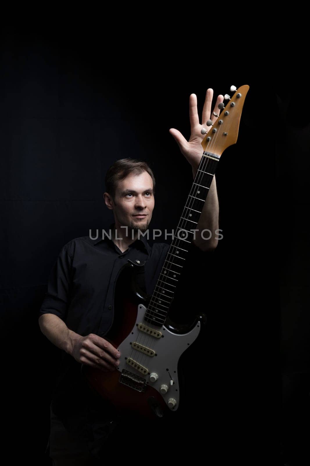 Young male guitarist playing with electric guitar.