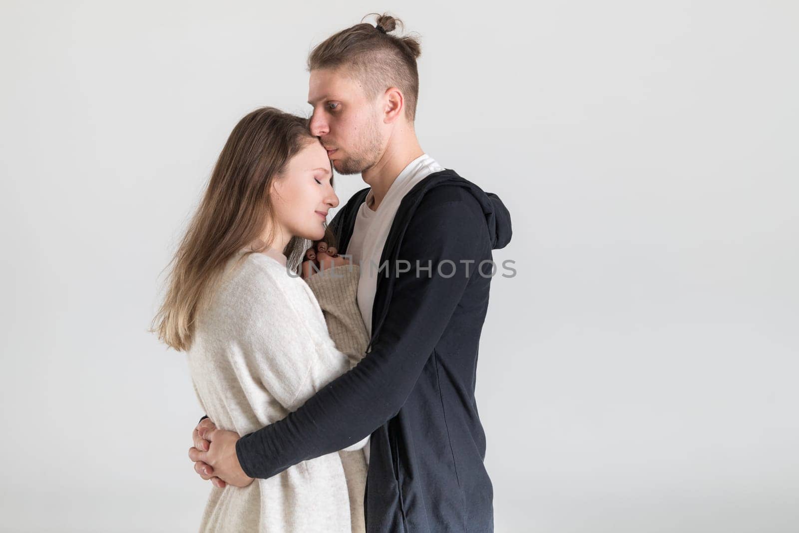 Portrait of a young caucasian couple hugging lovers on a white background by Rom4ek