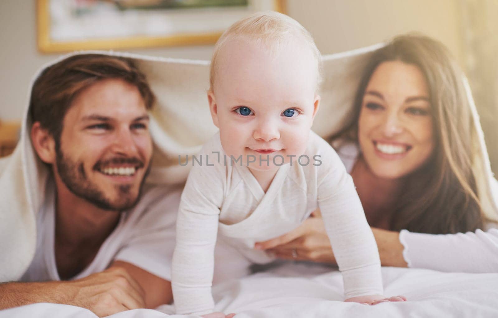 My parents and me. a young couple and their baby daughter in the bedroom. by YuriArcurs