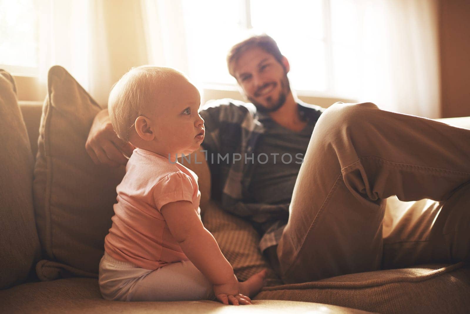 Watching her grow up. a young father and his baby daughter in the living room. by YuriArcurs