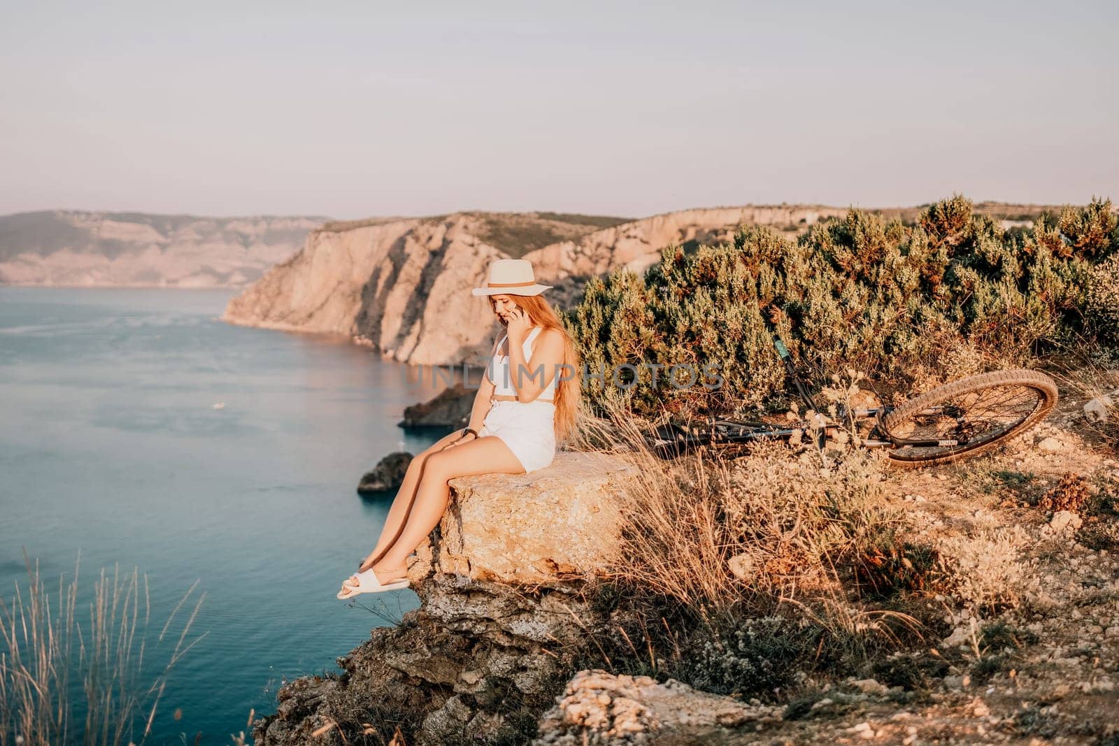 Woman travel sea. Young Happy woman in a long red dress posing on a beach near the sea on background of volcanic rocks, like in Iceland, sharing travel adventure journey