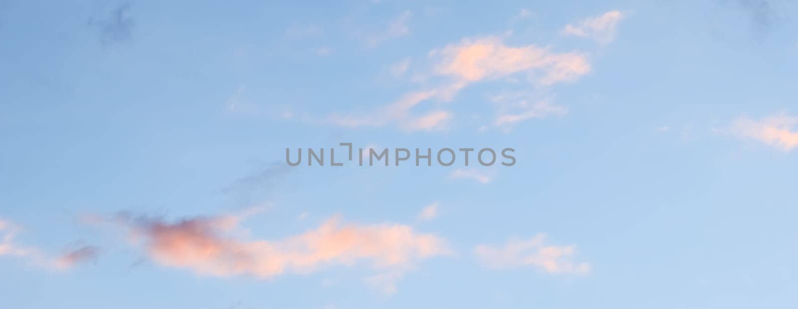 Blue sky background with pale pink clouds at sunset by Olayola