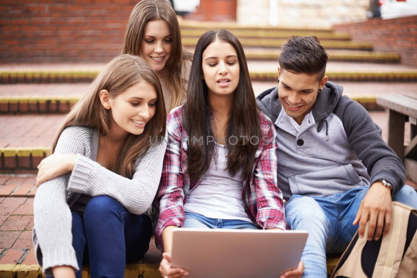 Loving life on campus. university students using a laptop on campus