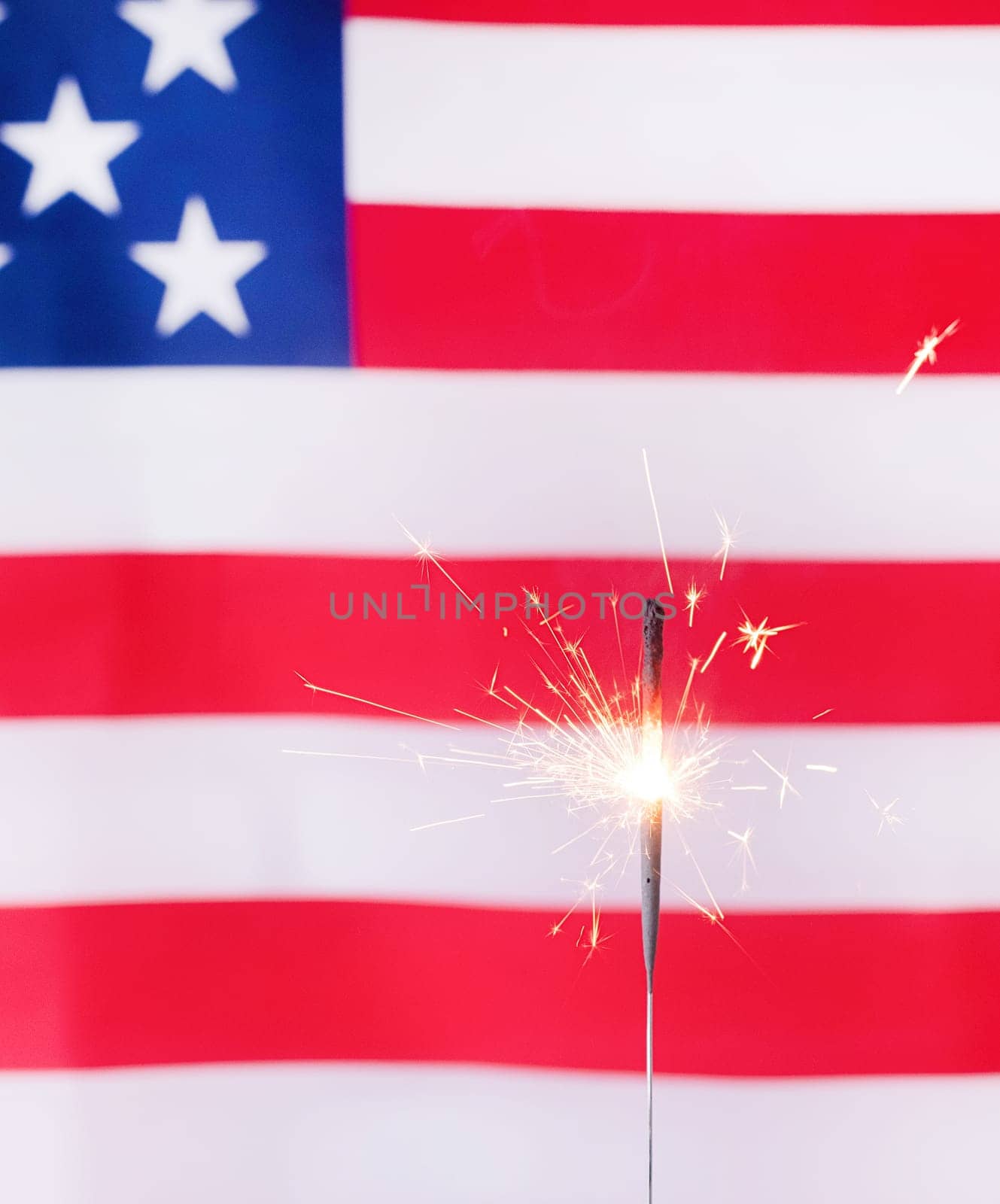 Shining sparkler over USA flag background by Desperada