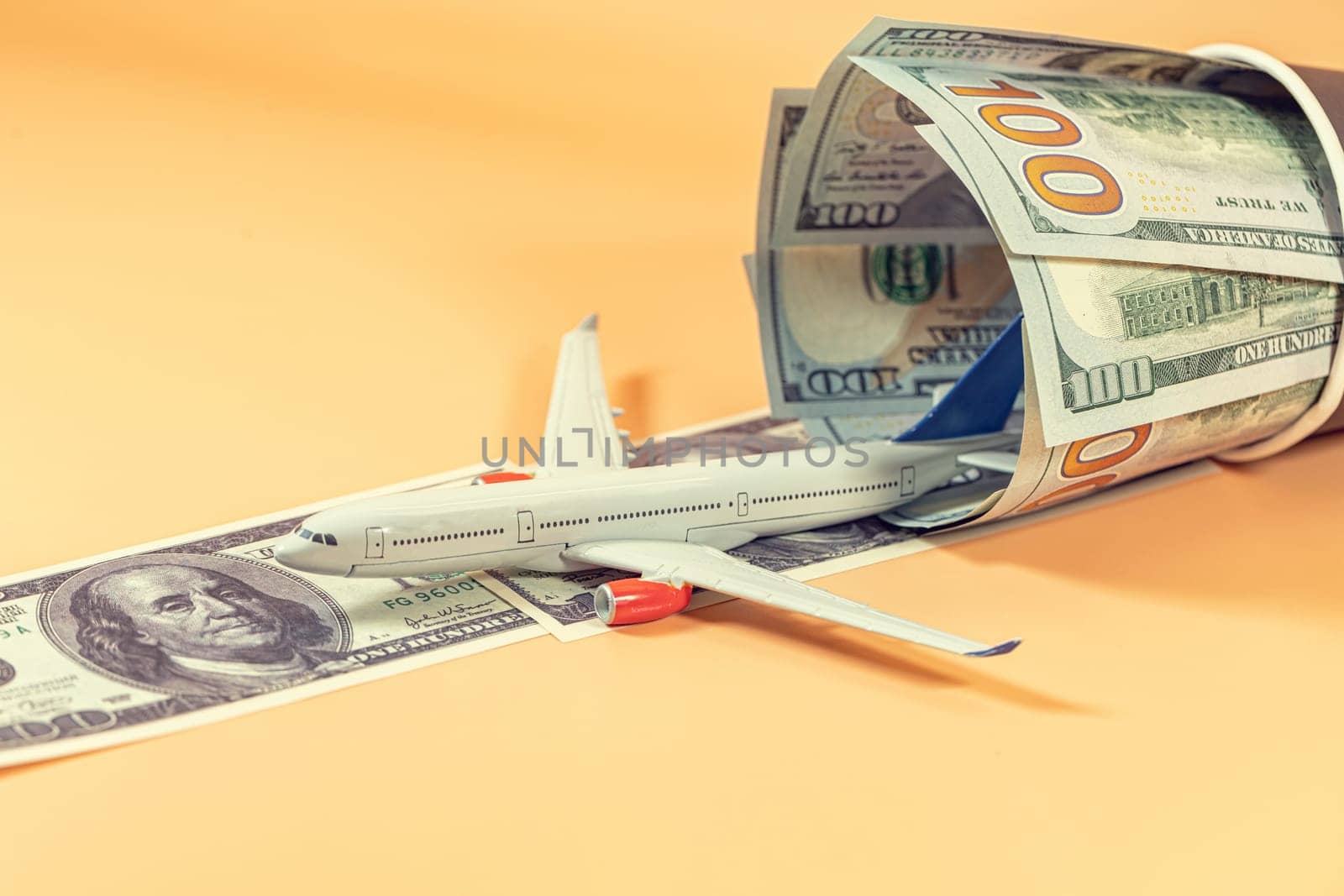 A toy airplane takes off on a runway of dollar bills