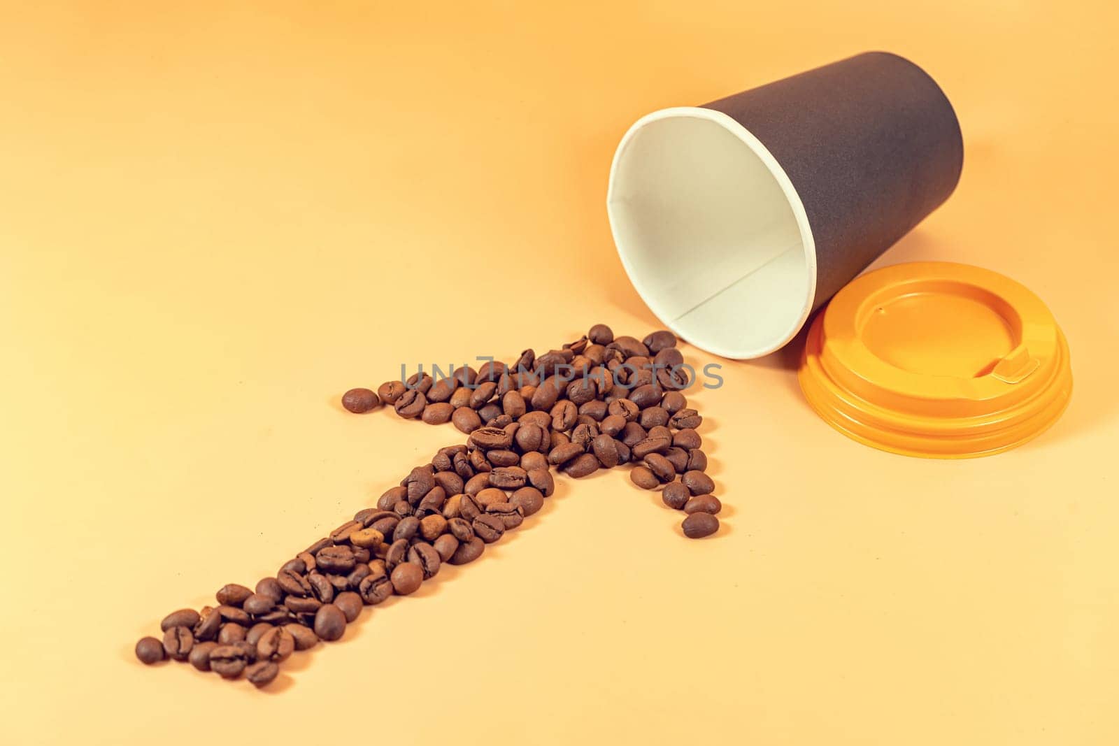 An arrow made of coffee beans points to a disposable paper cup