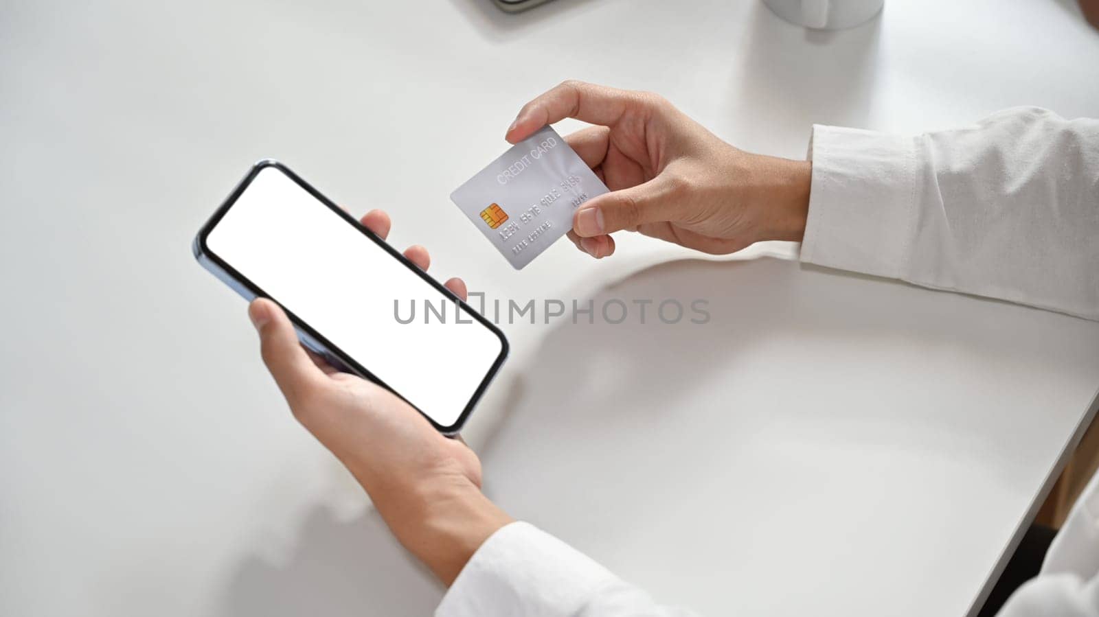 Close up view man hand holding smart phone and credit card, online shopping, e-commerce, internet banking concept by prathanchorruangsak