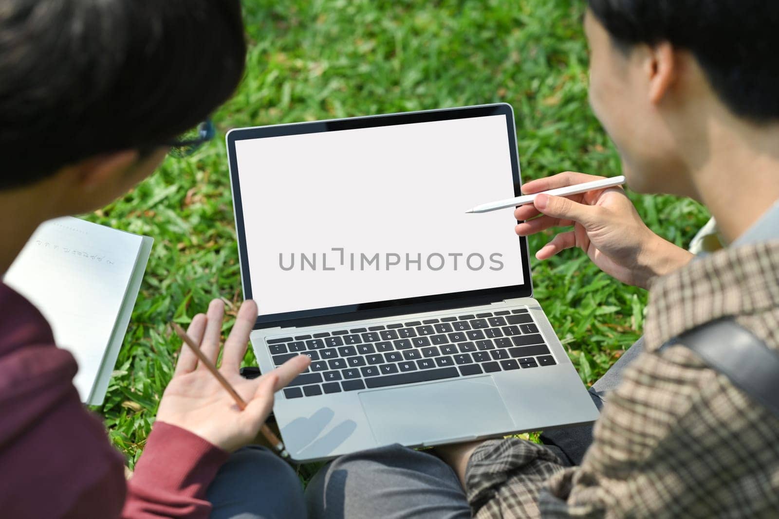 University students looking at screen of laptop, working on digital project together. Education, technology and community concept by prathanchorruangsak