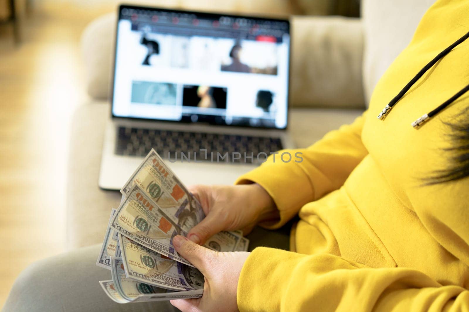 Successful online business concept hands counting dollar bills background of open laptop. It conveys idea of financial success, wealth management, and profitability, providing inspiring image for business and finance-related projects. by LipikStockMedia
