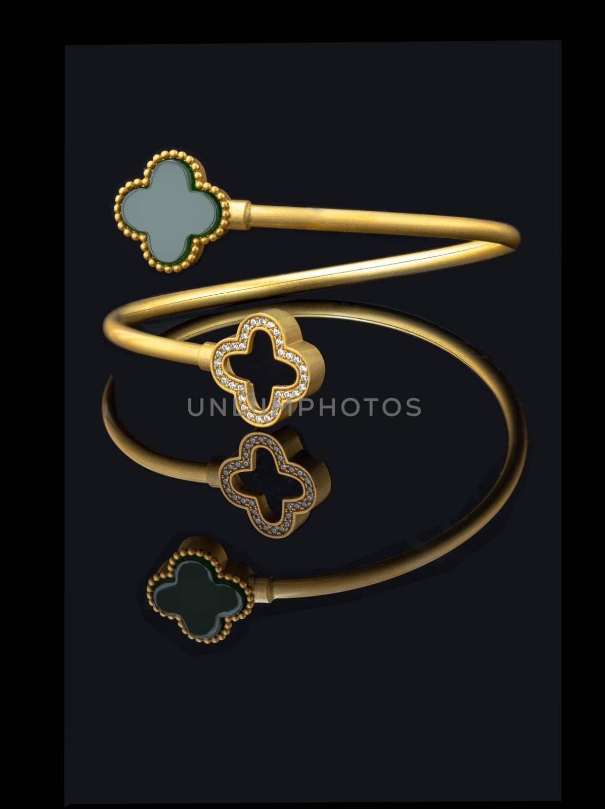Bangkok, Thailand - Apr 03, 2023 - Romantic Beautiful Gold Bracelet with Jade and Many Precious Diamonds Shown on a Black Reflection Background. Elegant Woman Jewelry is isolated on the Black Color Background, Special Occasion Accessories. Space for text.