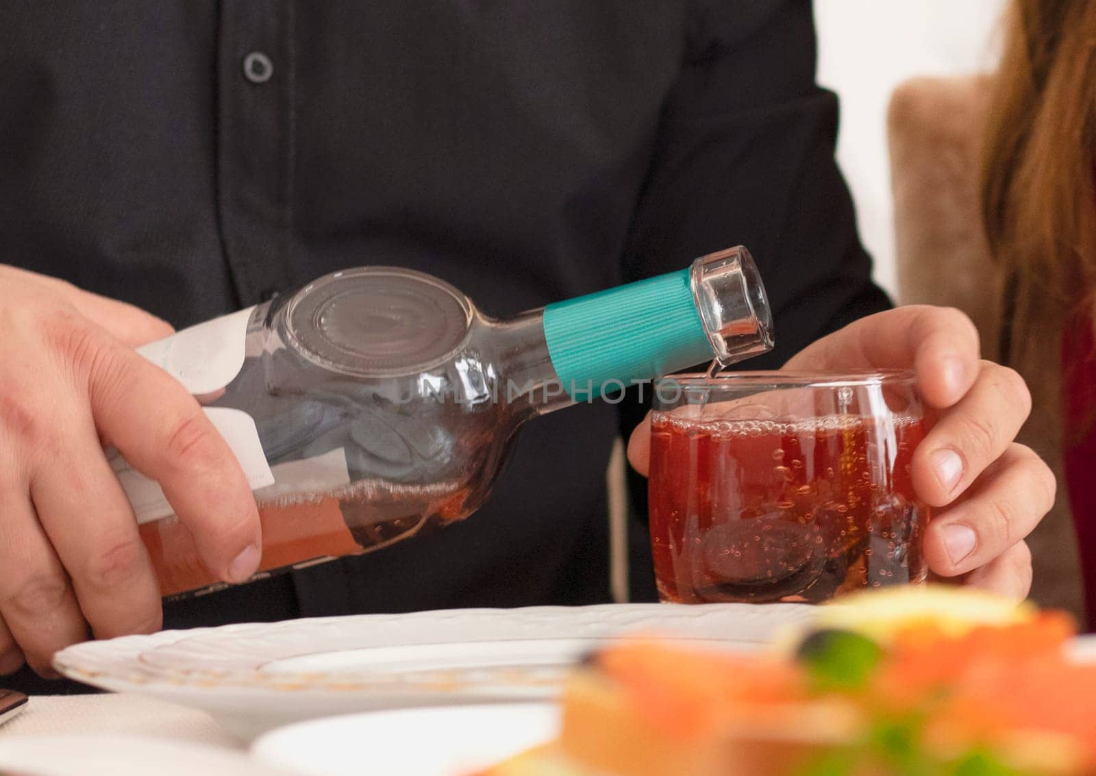 Young man pouring wine from the bottle into a glass . wine at restaurant. High quality photo