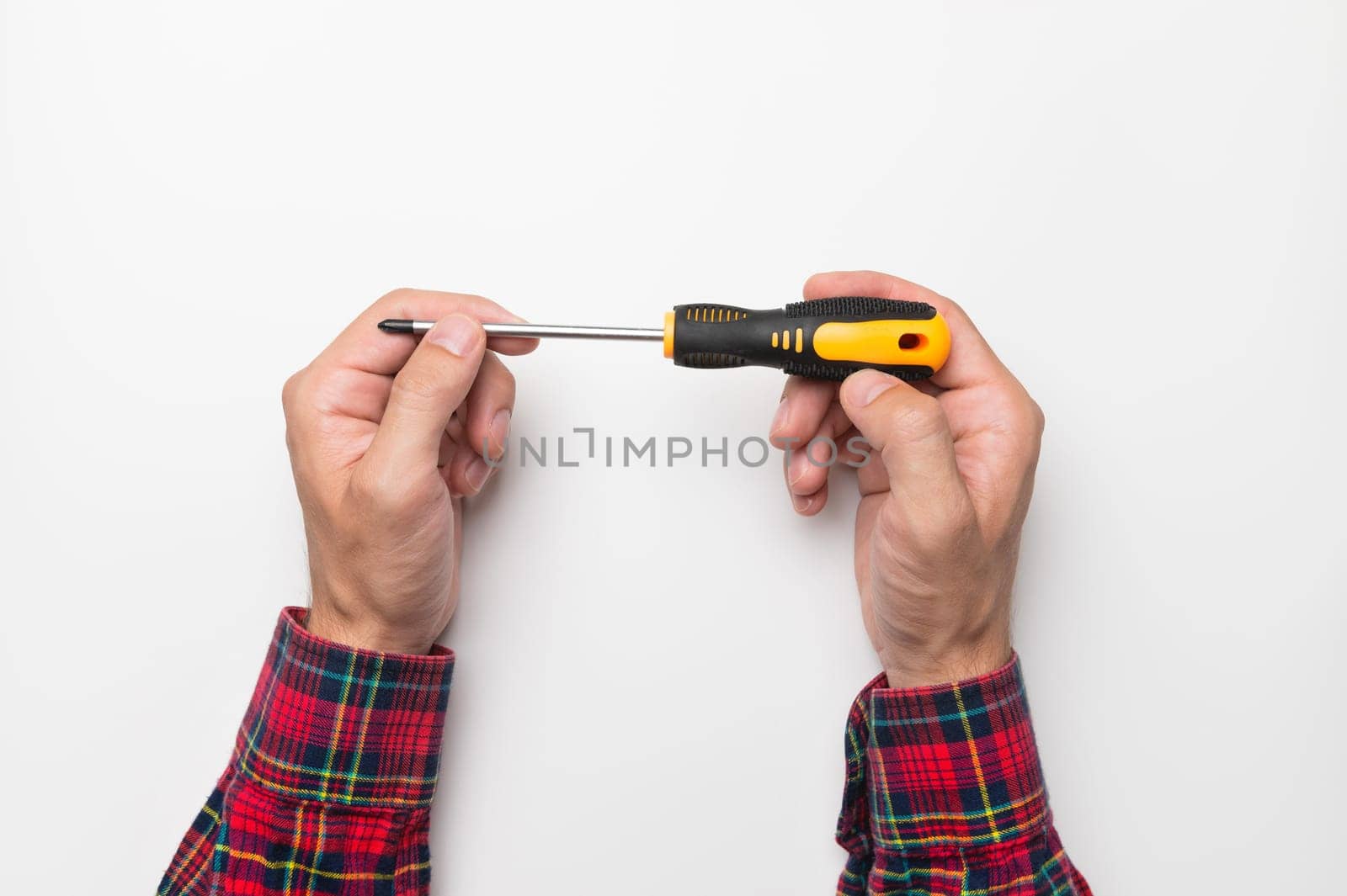 screwdriver in a male hand on a white background, top view. layout for text, phrases, inscriptions.