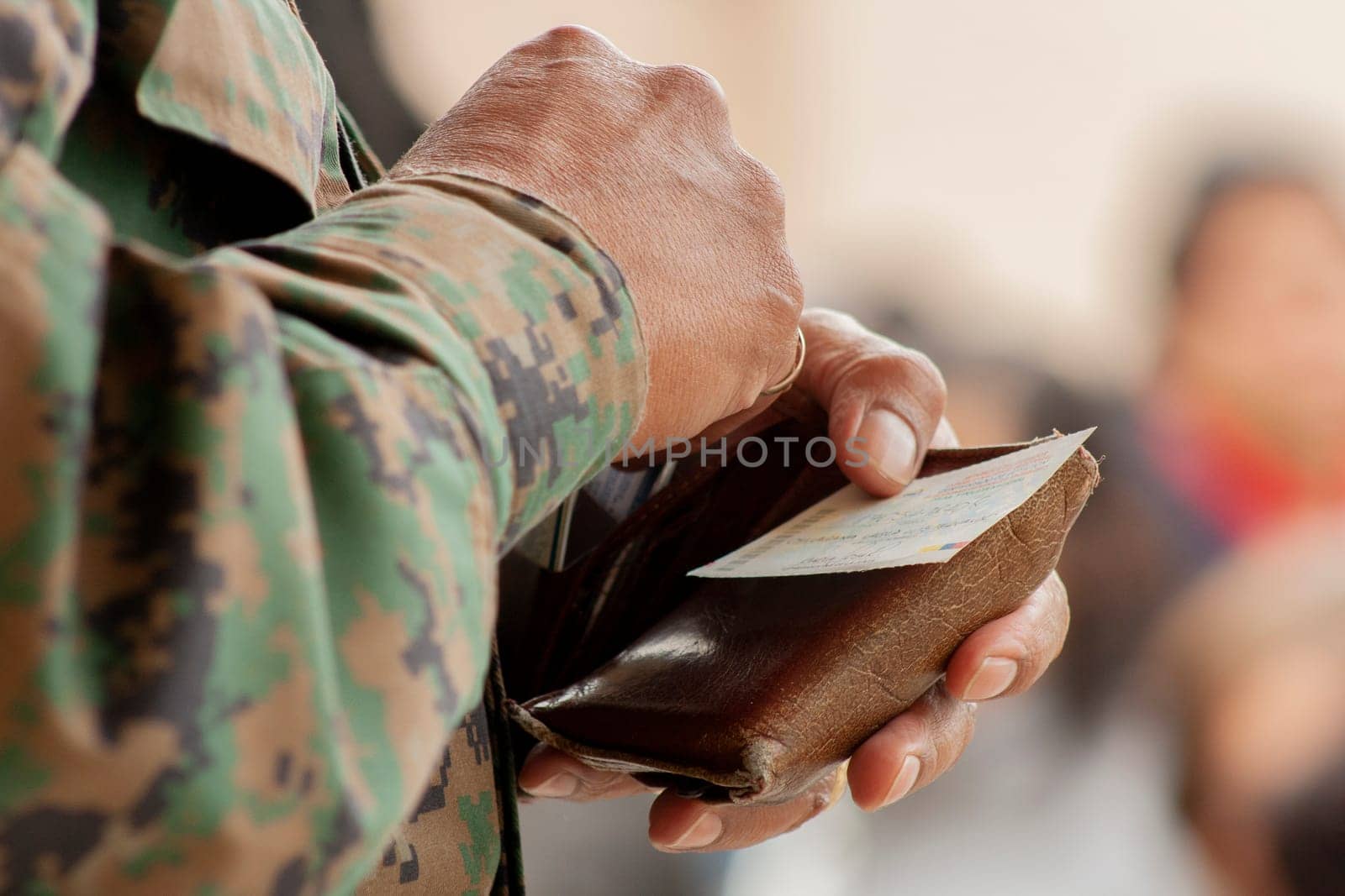 close-up of the hand of a military man with his wallet in his hand and a card. High quality photo
