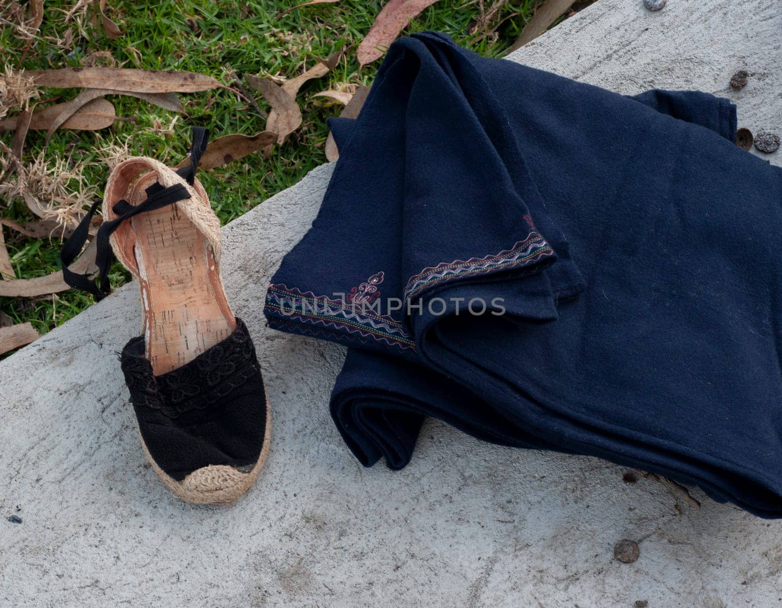 close-up of handmade footwear with hand-embroidered fabric on a field stone. High quality photo