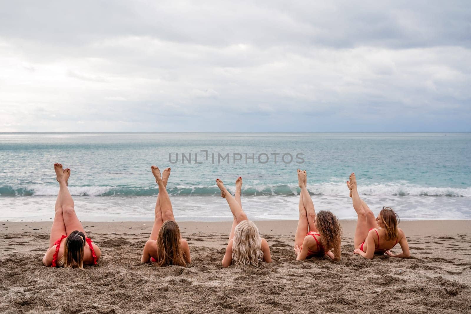 Big happy family or group of five friends is having fun against sunset beach. Beach holidays concept