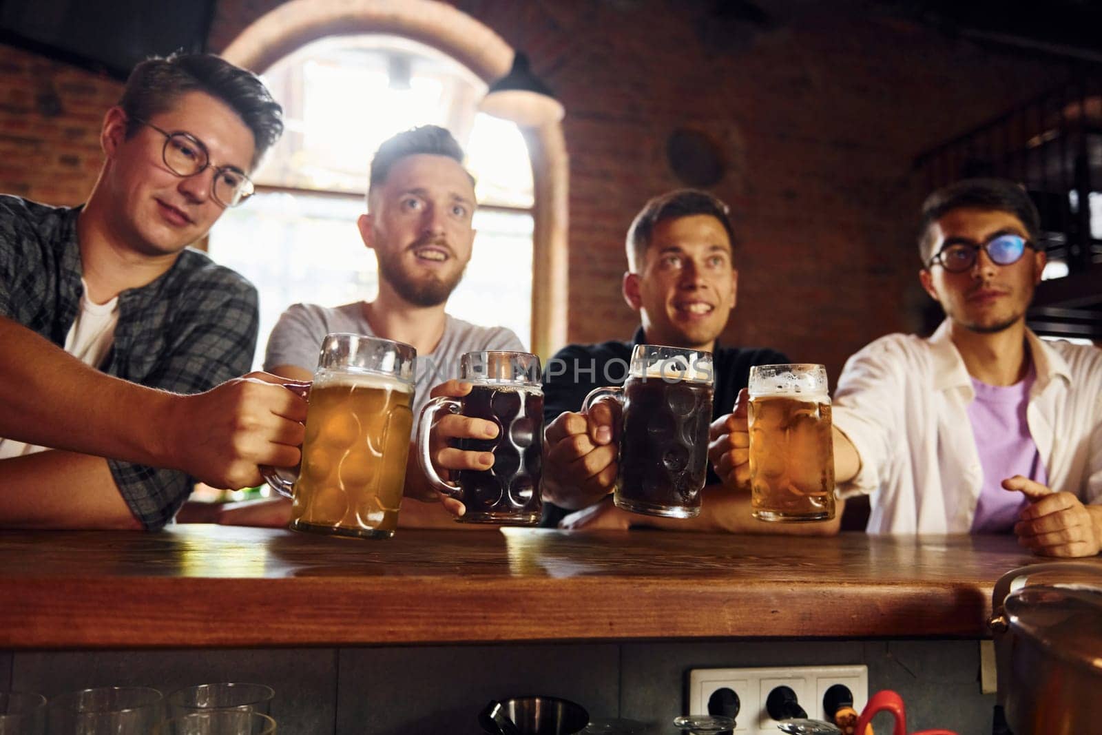 Drinking beer. People in casual clothes sitting in the pub.