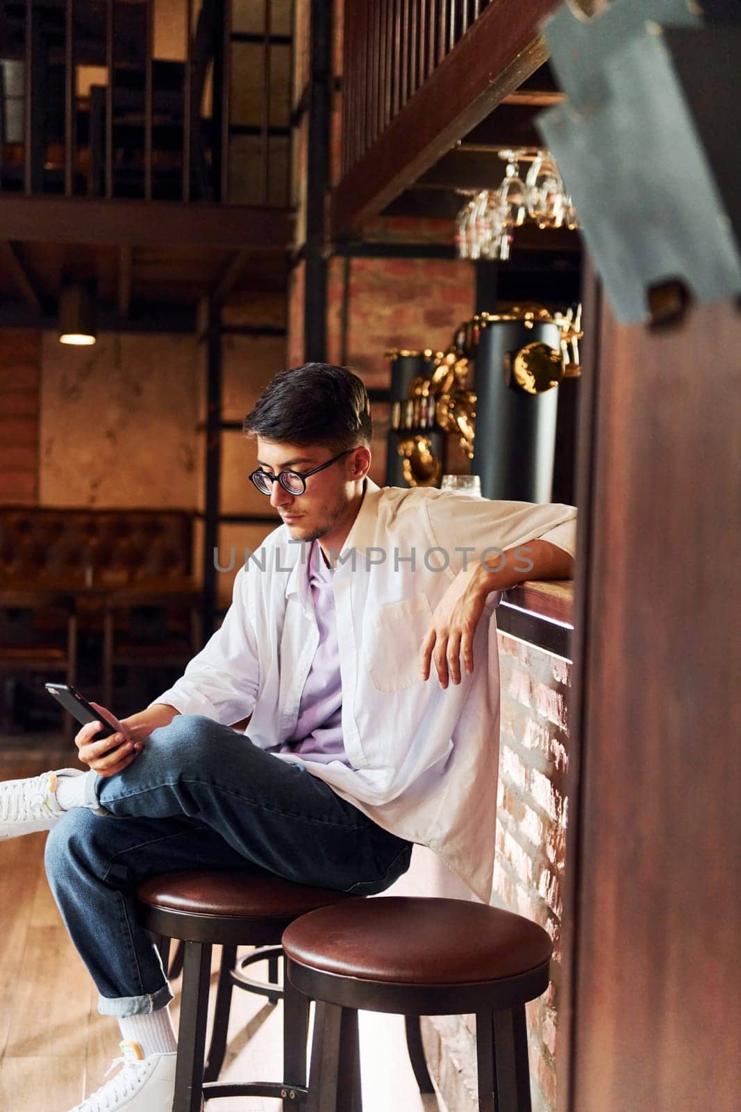 One person. Man in casual clothes sitting in the pub.