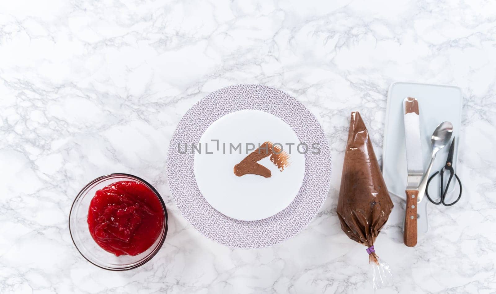 Flat lay. Covering chocolate cake with a crumb layer of chocolate buttercream frosting.