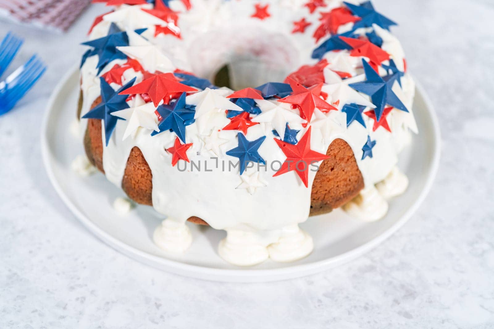 July 4th bundt cake covered with a vanilla glaze and decorated with chocolate stars on a white plate.