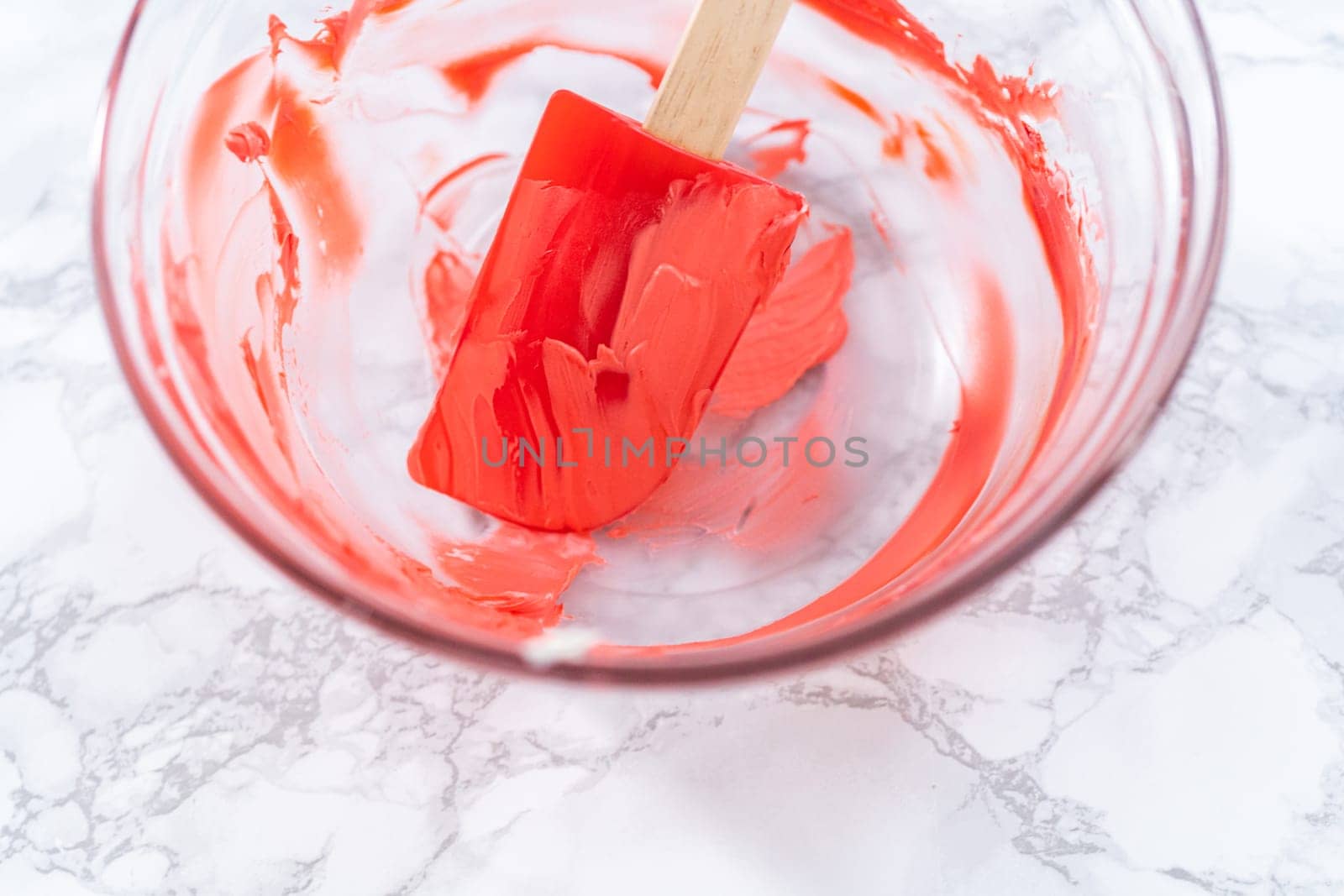 Dirty kitchen tools in a glass mixing bowl after baking a cake.