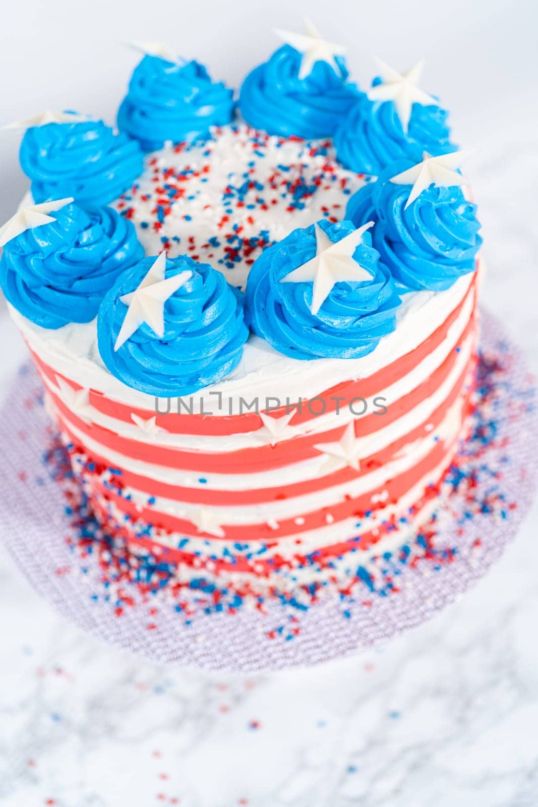 Decorating chocolate cake with white, red, and blue buttercream frosting for July 4th celebration.