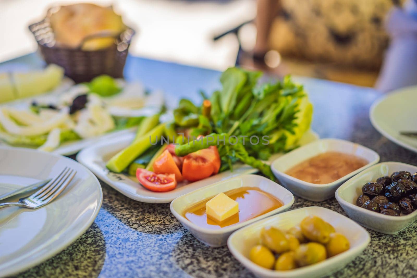 Turkish breakfast table. Pastries. Vegetables. Olives. Cheeses, fried eggs. Jams, tea in copper pot and tulip glasses. Wide composition.