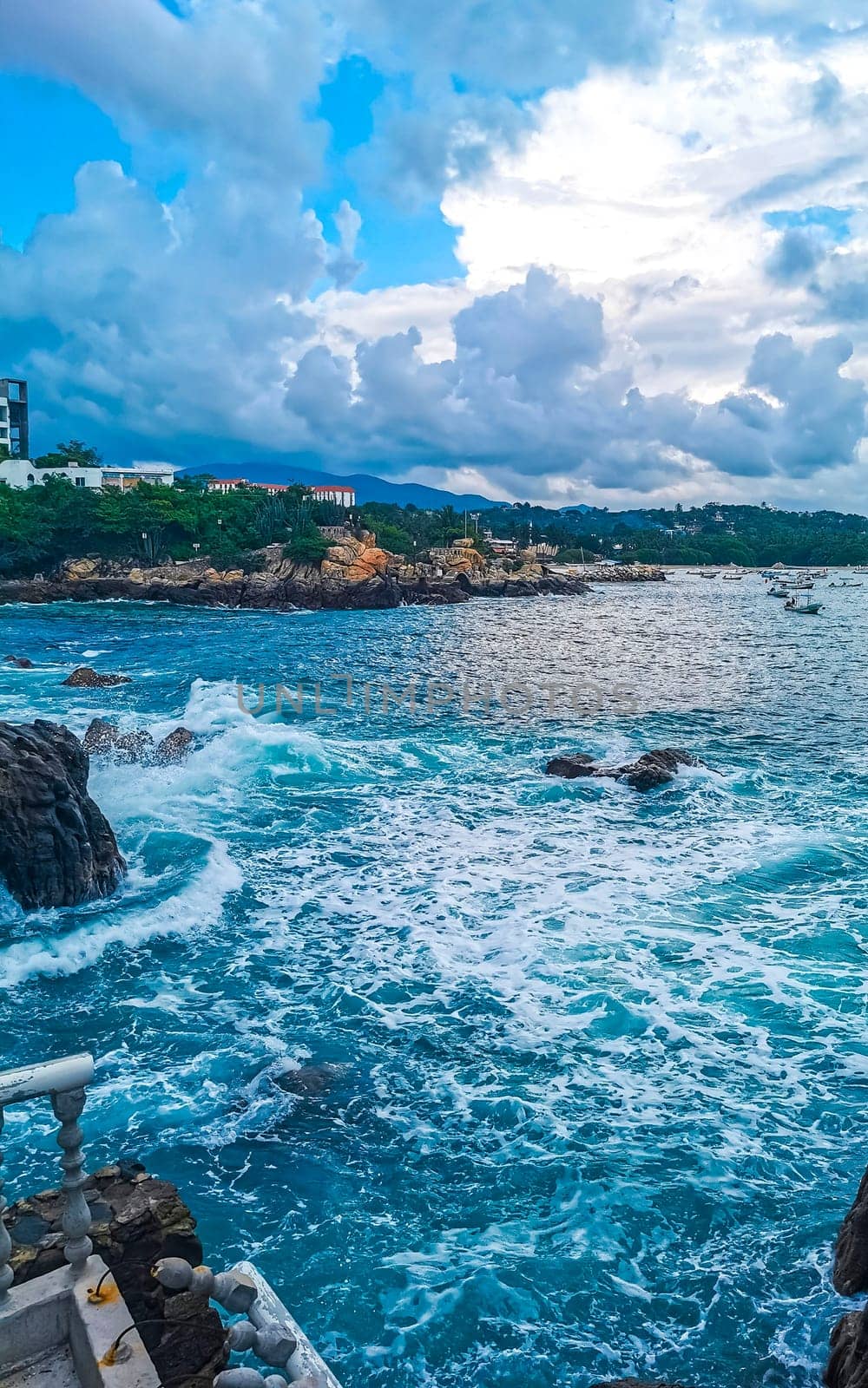 Beautiful surfer waves rocks cliffs at beach Puerto Escondido Mexico. by Arkadij