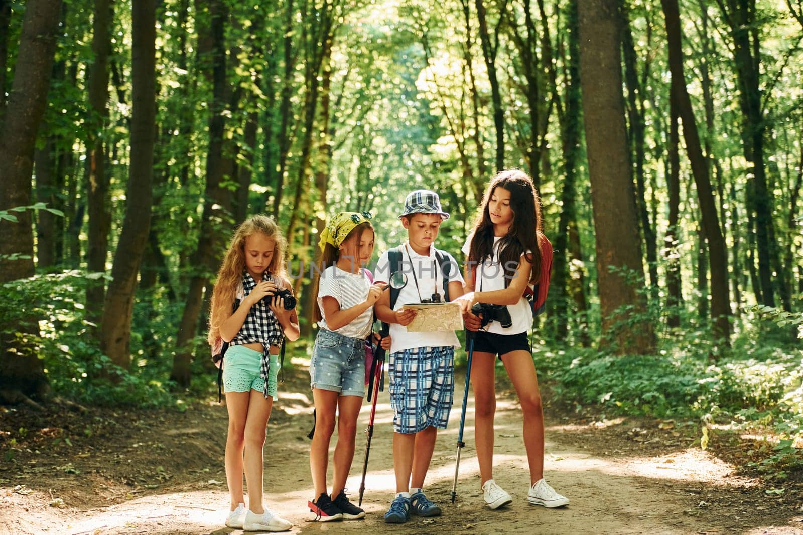 Weekend activies. Kids strolling in the forest with travel equipment by Standret