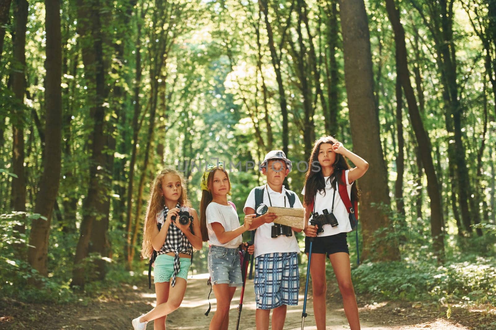 Weekend activies. Kids strolling in the forest with travel equipment.