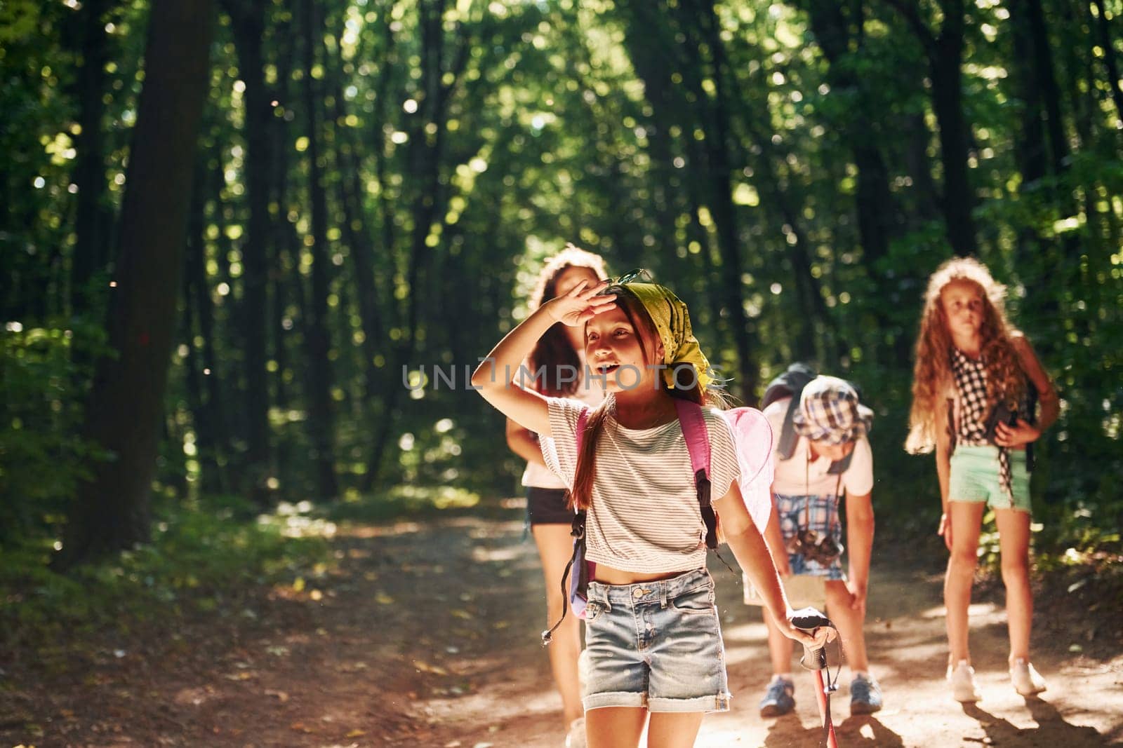 Girl looking far away. Kids strolling in the forest with travel equipment by Standret