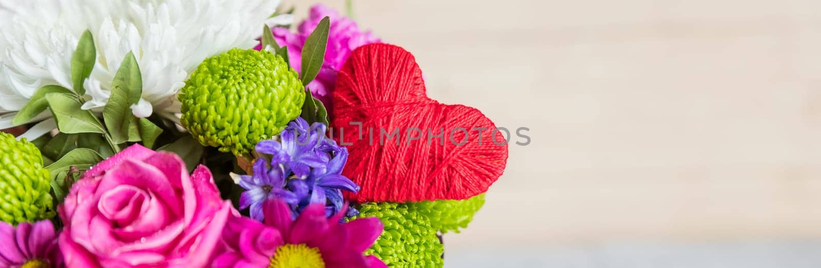 Chrysanthemum bouquet in a box and white straw heart on the white background. Nice card design for greeting with Valentine Day or Mothers Day.