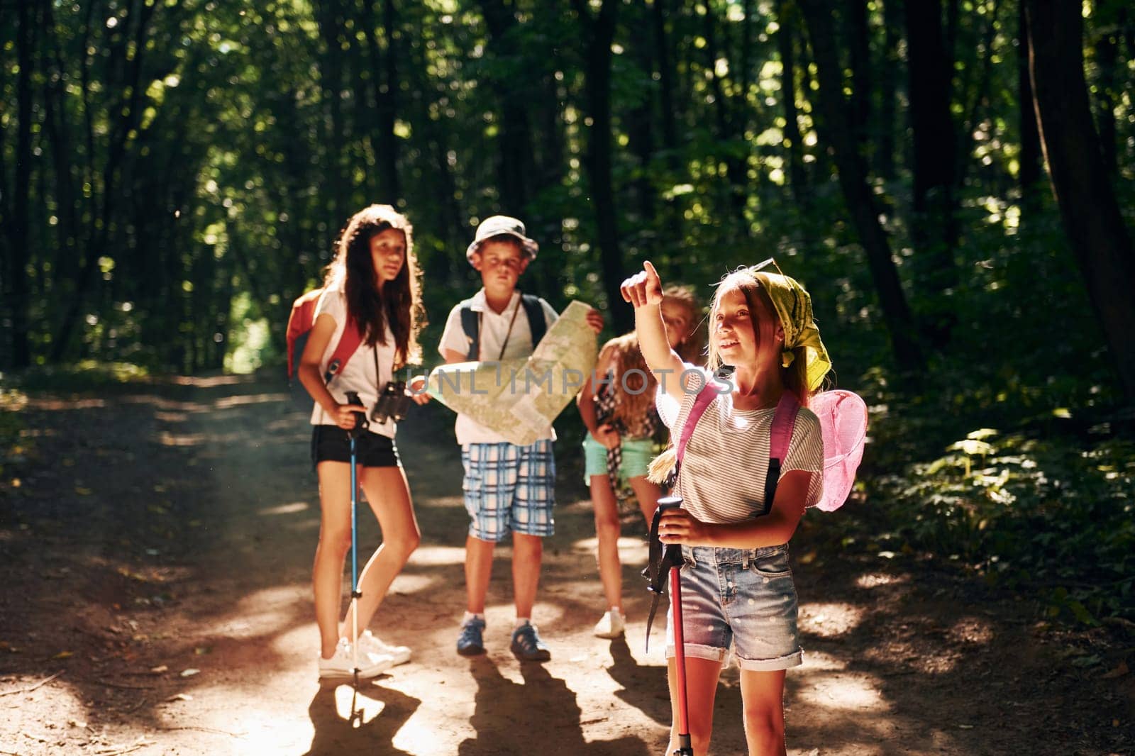 Posing for the camera. Kids strolling in the forest with travel equipment by Standret