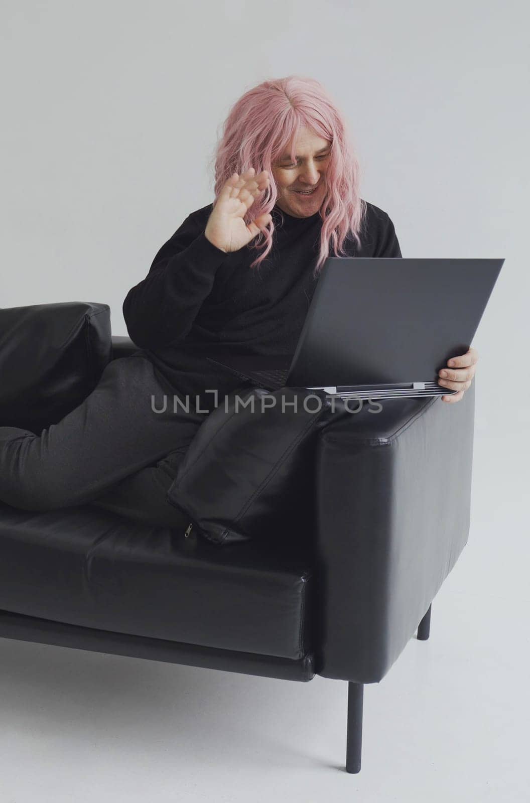 A man in a pink wig, sits on a sofa, communicates via video link on a laptop. by Sd28DimoN_1976