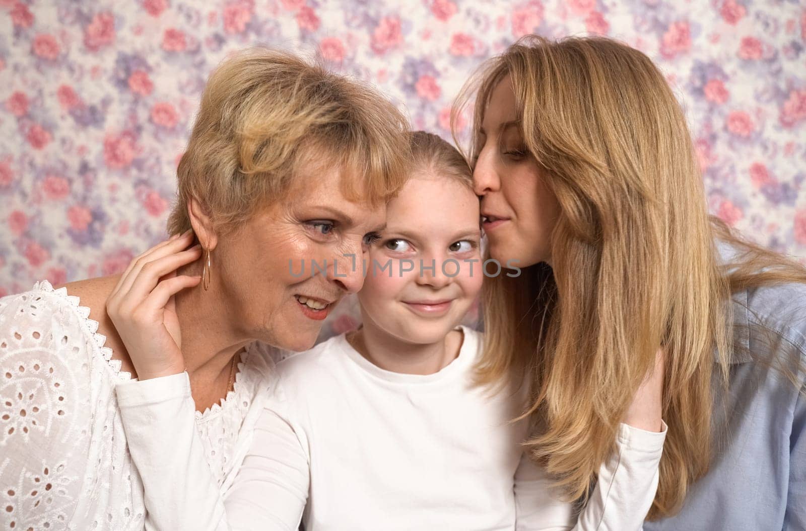 A teenage girl hugs her grandmother and mother, expresses her love to them.