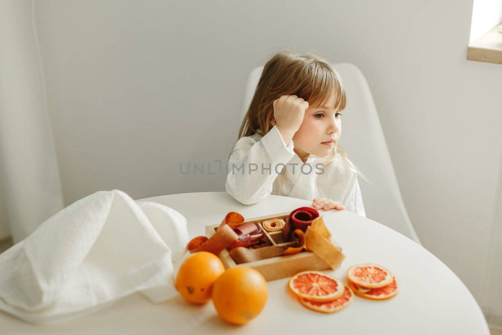 Portrait of a young girl in a dressing gown, who is sitting in the kitchen, next to a box of marmalade, candied fruits by Sd28DimoN_1976