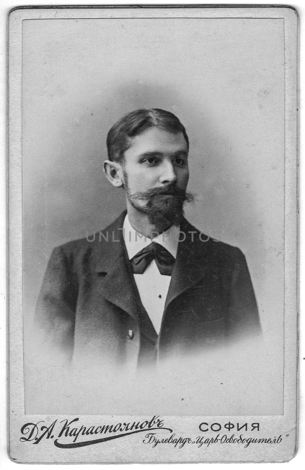 SOFIA, BULGARIA - CIRCA 1910: Vintage cabinet card shows portrait of the midle-aged man with moustache, full beard. Photo was taken in a photo studio. Edwardian era.