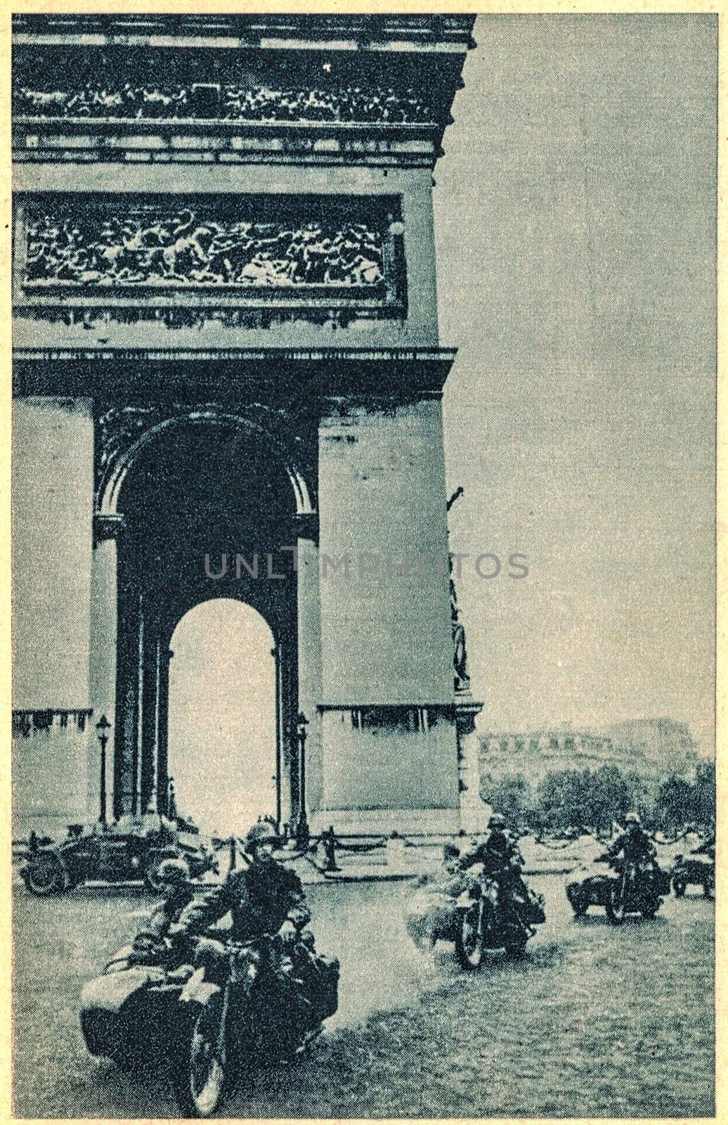 PARIS, FRANCE - JUNE,1940: German troops ride around Arc de Triomphe in Paris. Nazi Germany invaded in France in 1940.