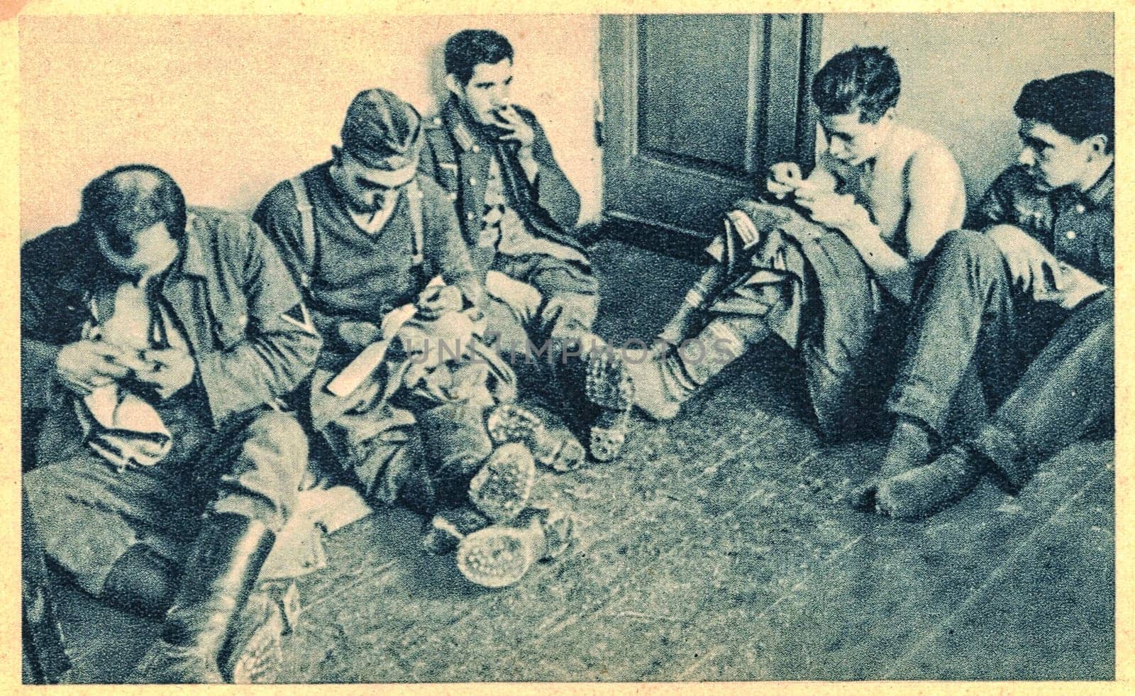 German war prisoners in time of silence. Time for repairing of clothes. German soldiers in POW camp. by roman_nerud