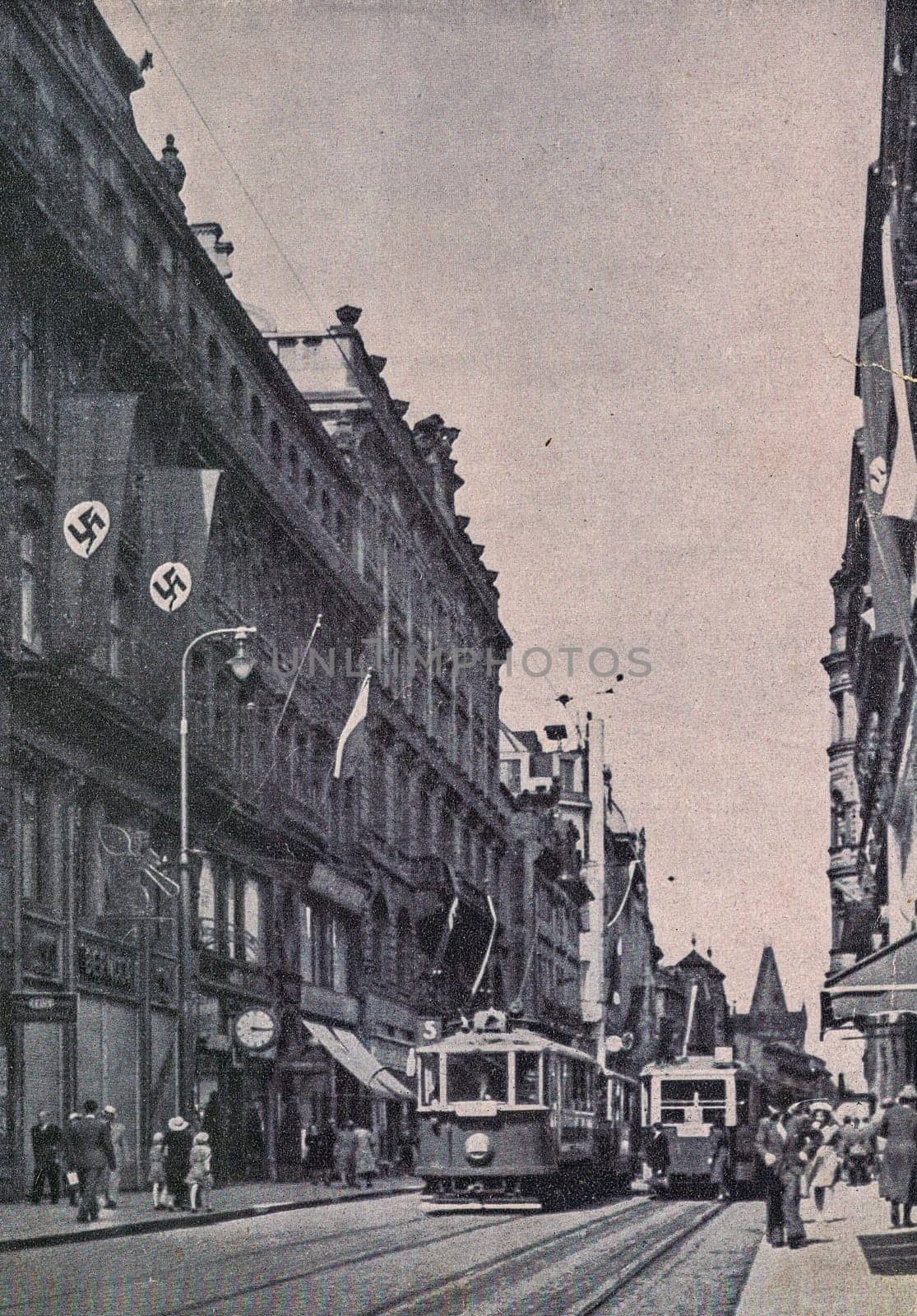 PRAGUE, PROTECTORATE OF BOHEMIA AND MORAVIA - 1942: Unkown street in Prague. Nazi Swastika flags on building.