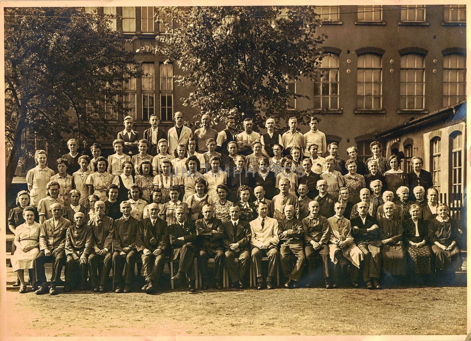 OBERLUNGWITZ, GERMANY - AUGUST 4, 1942: Retro photo shows people (employees of school) in front of building. Vintage black white photography.