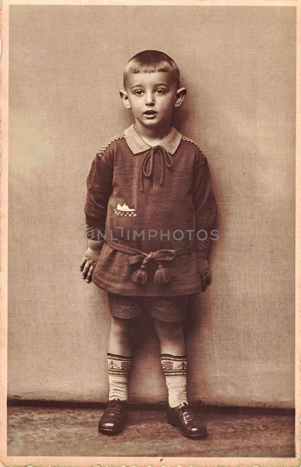 Vintage photo shows little boy. Circa seven to eight year old. Studio black and white portrait. Sepia effect. by roman_nerud