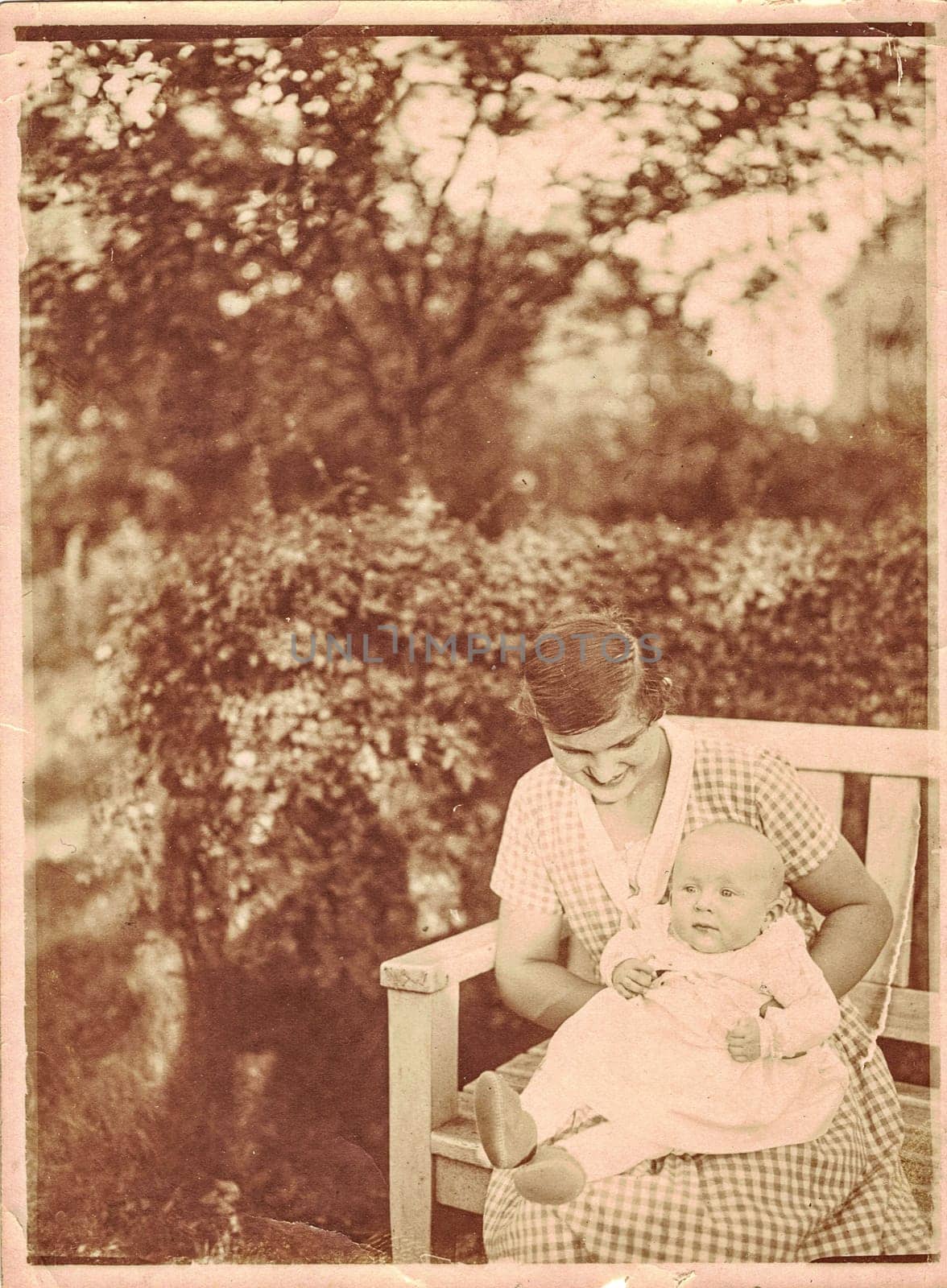 GERMANY - CIRCA 1940: The vintage photo shows mum and her baby child-girl. Baby child is 6 months old. Photo with sepia effect.
