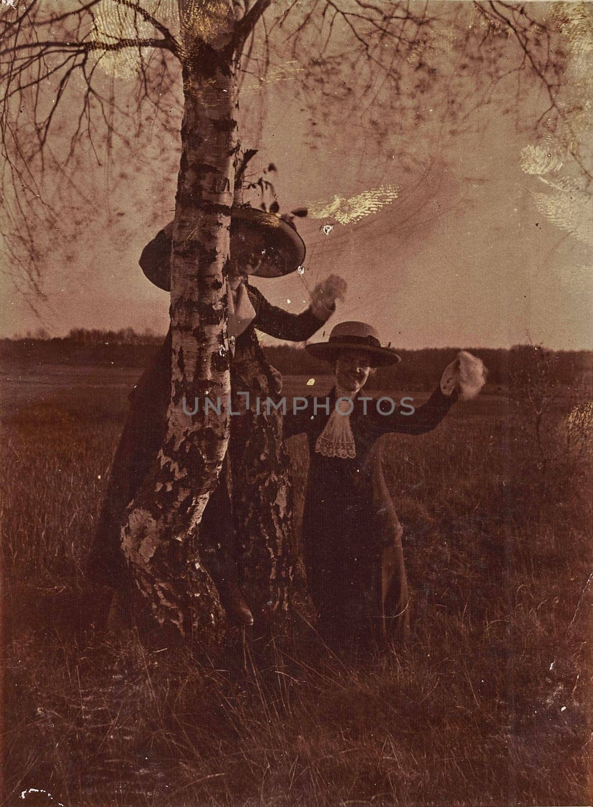Vintage photo shows two ladies outdoor. Photo with sepia effect and has fingerprints imperfection. Black and white photography. by roman_nerud