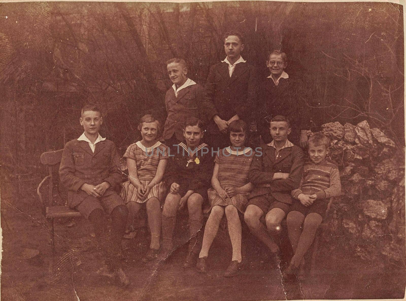 GERMANY - 1929: Vintage photo shows group of young people pose outdoor. Photo with sepia effect.