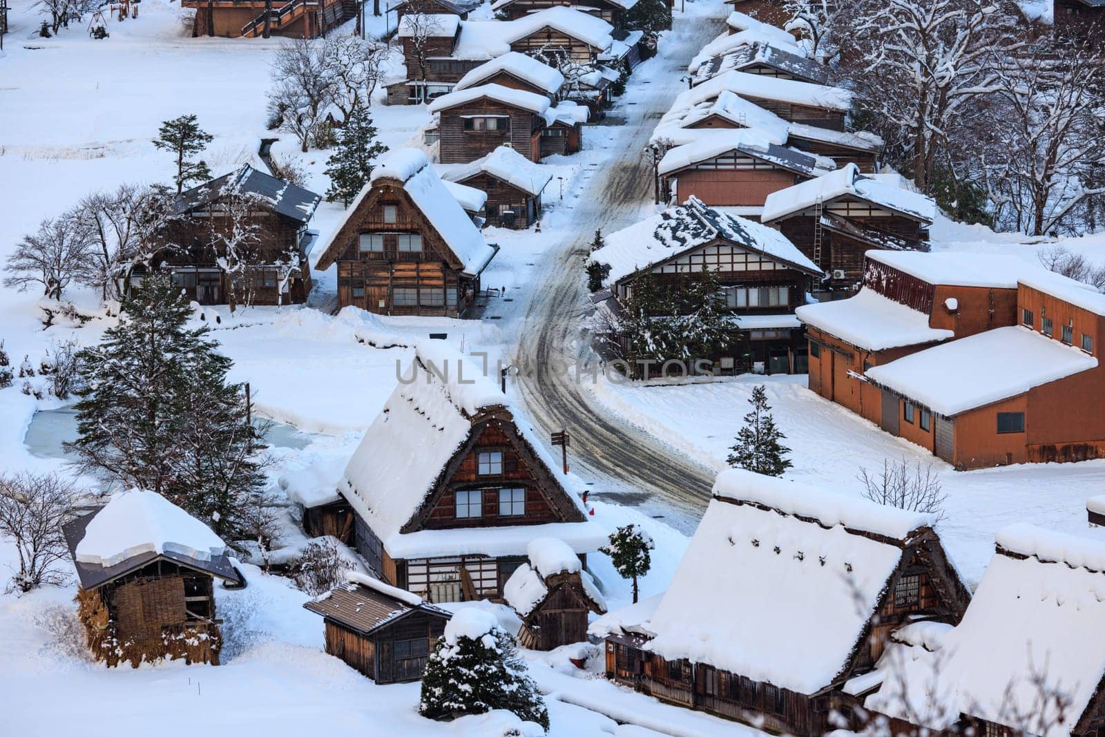Snow covered A-frame roofs in historic Japanese mountain town in winter by Osaze