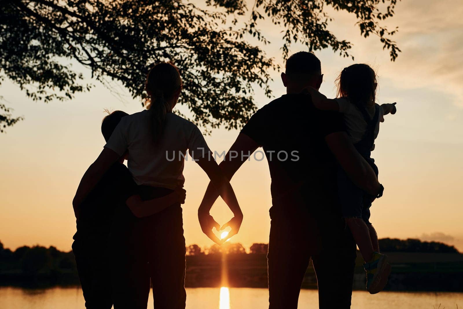 Looking at sunset. Family of mother, father and kids is on the camping.