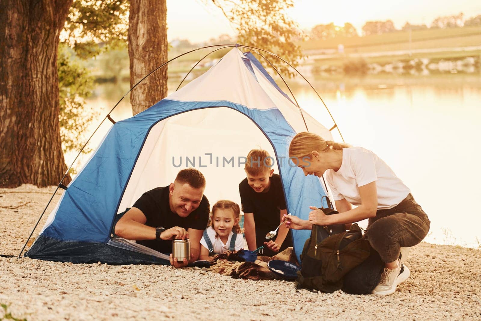 Conception of vacation. Family of mother, father and kids is on the camping by Standret
