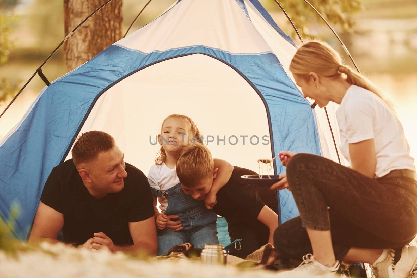 Conception of vacation. Family of mother, father and kids is on the camping.