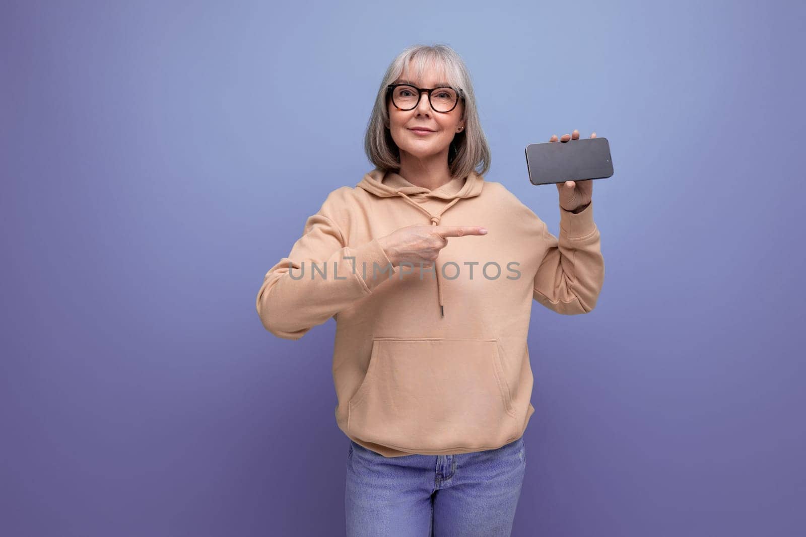 portrait of a confident 60s woman with gray hair who masters cashless payments by credit card on a studio background with copy space.
